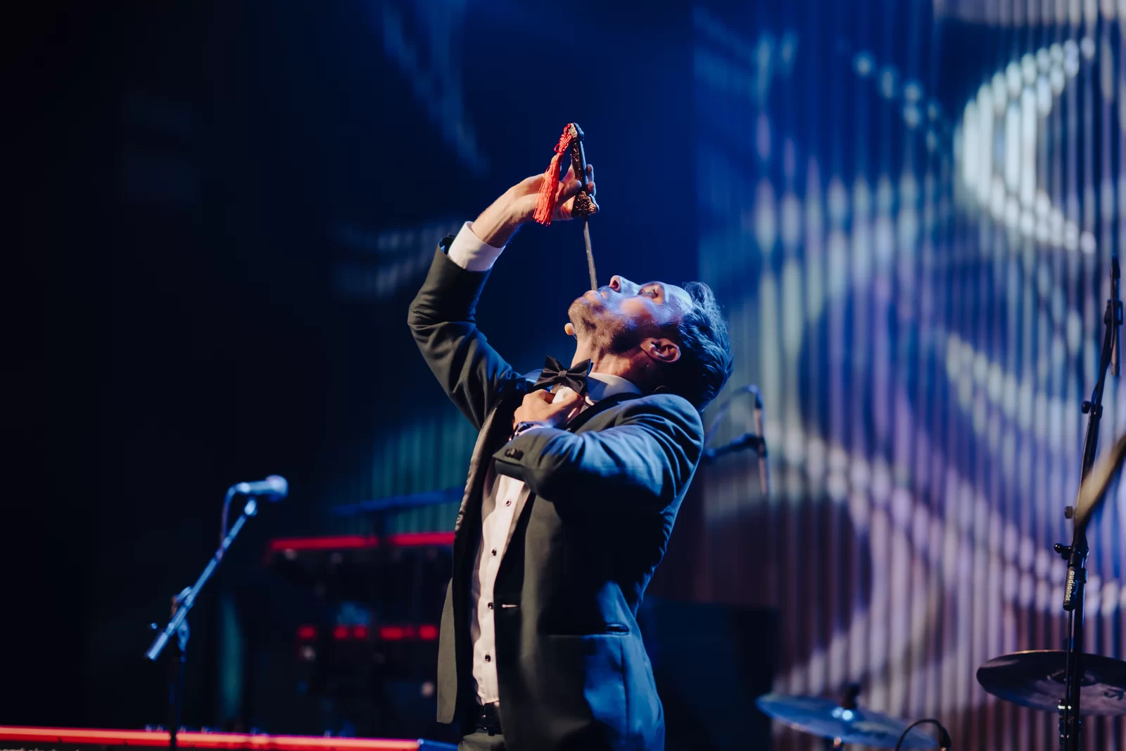 Hans Grane i smoking på scenen under et firmashow