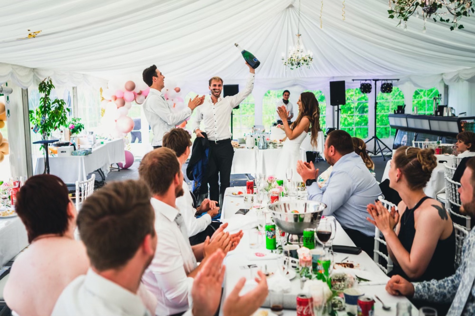 Hans Grane som toastmaster i et bryllup hever champagnen mens gjestene applauderer