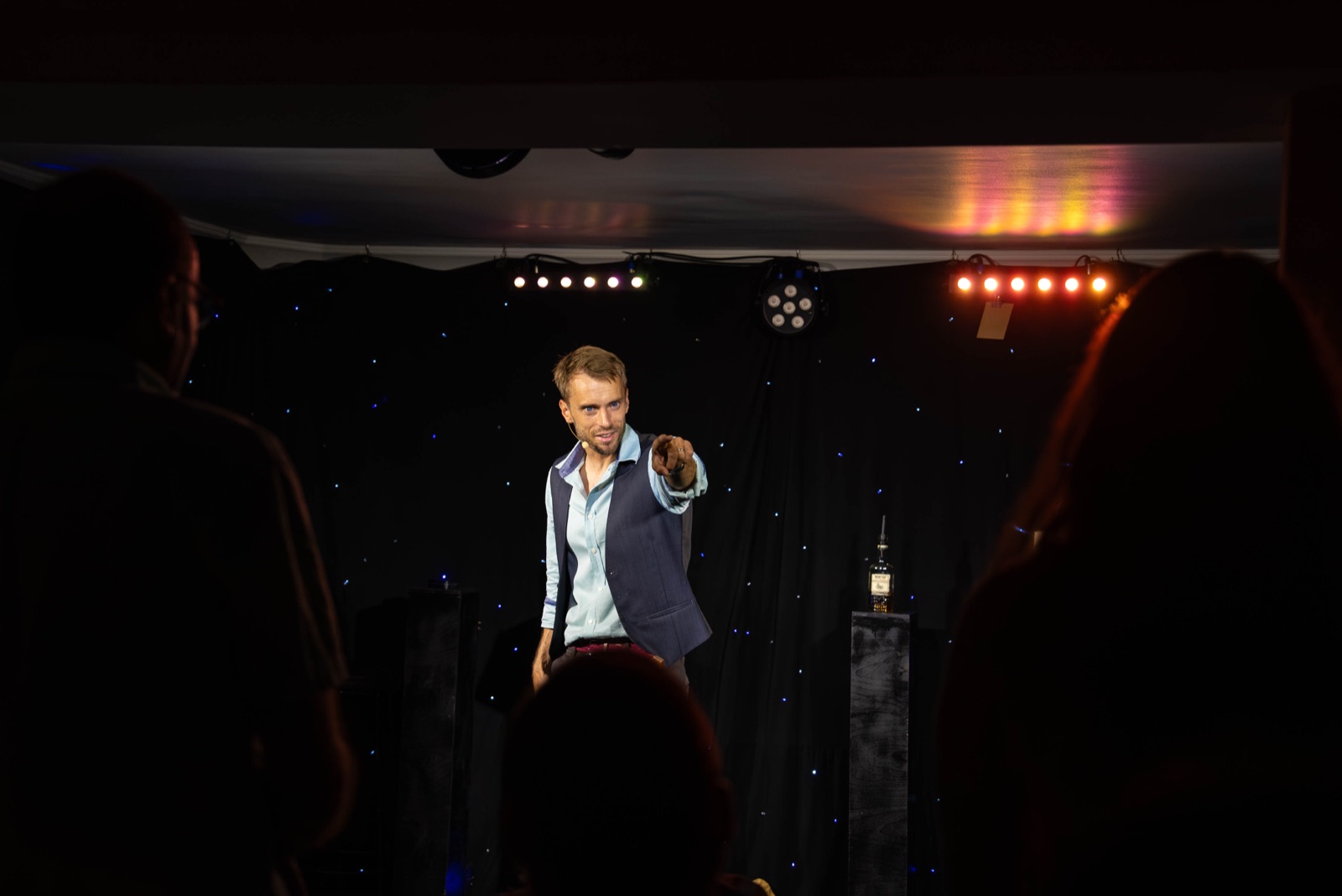 Hans Grane som komiker p&aring; scenen peker mot publikum under et show